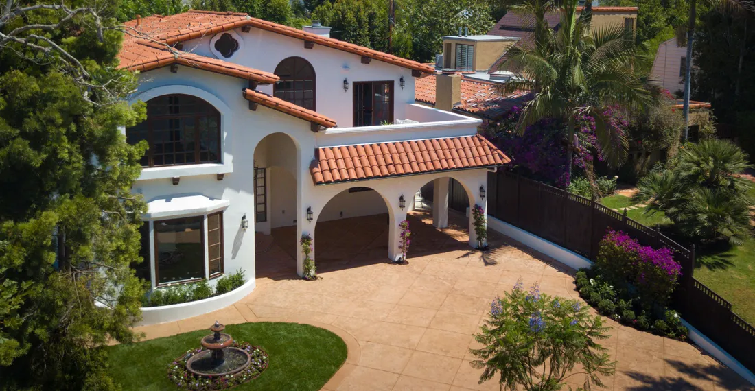 Spanish estate with a terracotta tile roof, arched entrance and landscaped courtyard