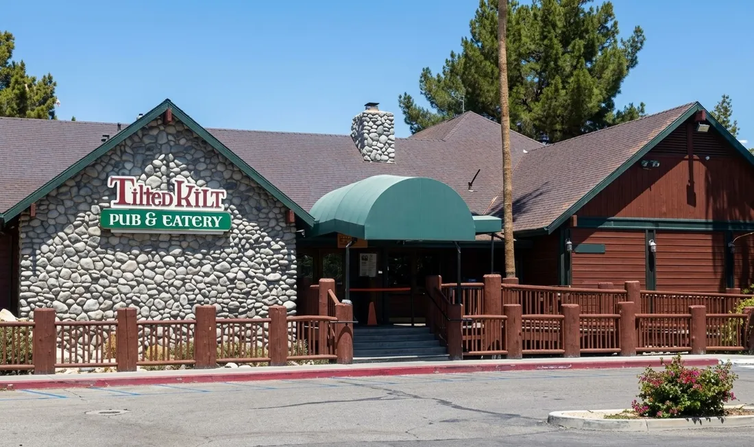 Stone-fronted Tilted Kilt Pub & Eatery building with a green awning