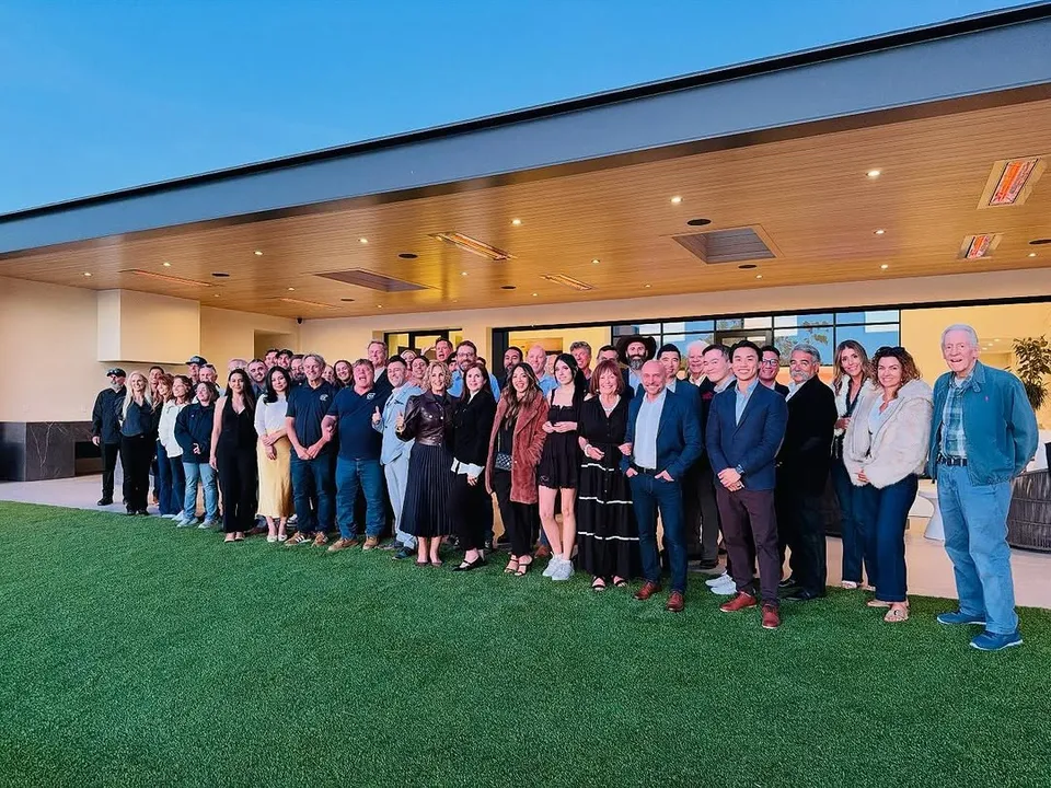 Watch-party guests posing together beneath a terrace